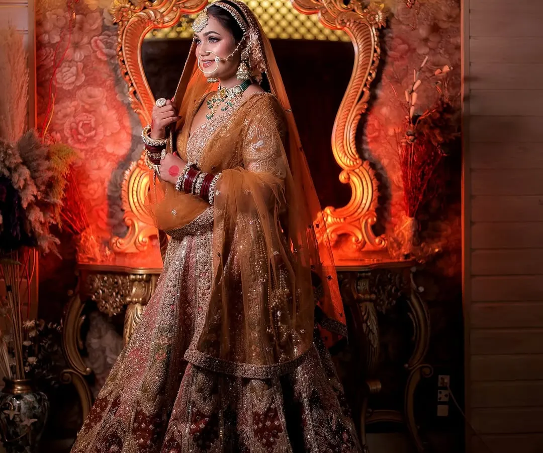This full-length portrait showcases the grandeur of a bridal lehenga against a regal, warmly lit backdrop. My goal is to create not just a photo, but a majestic scene that tells a story of elegance.