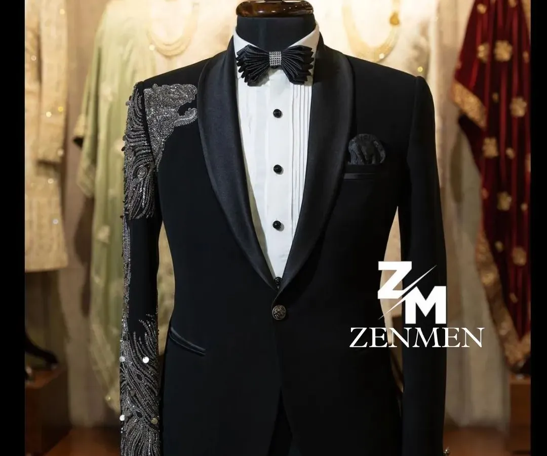 For the man who commands attention, this classic black tuxedo is elevated with striking silver hand embellishments on the sleeve and shoulder. It's a perfect example of modern luxury for a reception or black-tie event.