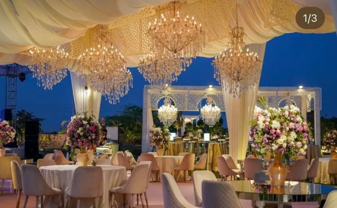 For this grand reception, we filled the venue with dozens of cascading crystal chandeliers to create a ceiling of light. The decor includes plush seating and coordinated floral arrangements, showcasing our expertise in luxury event design for large banquet halls.