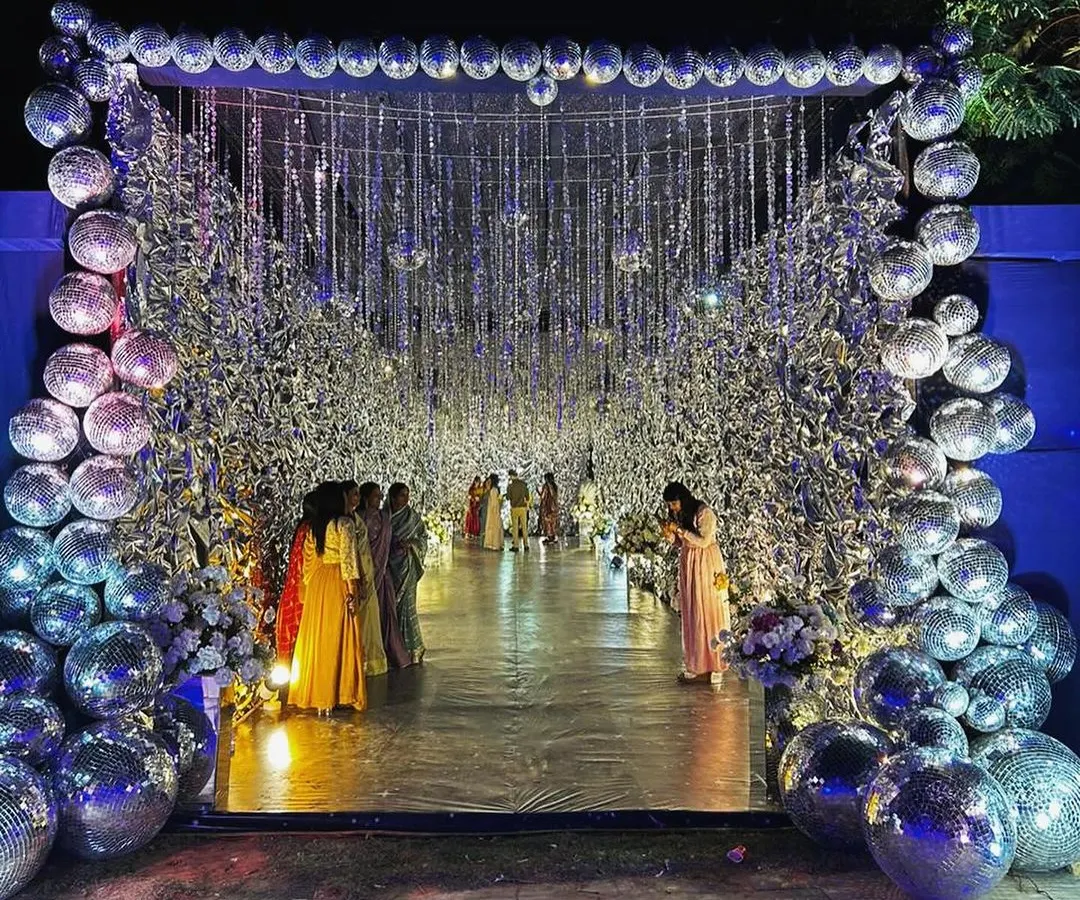 Making an entrance that hits different. For this Jaisalmer sangeet, we designed a glam and glitter tunnel with hundreds of disco balls, because why walk in when you can ✨arrive✨?