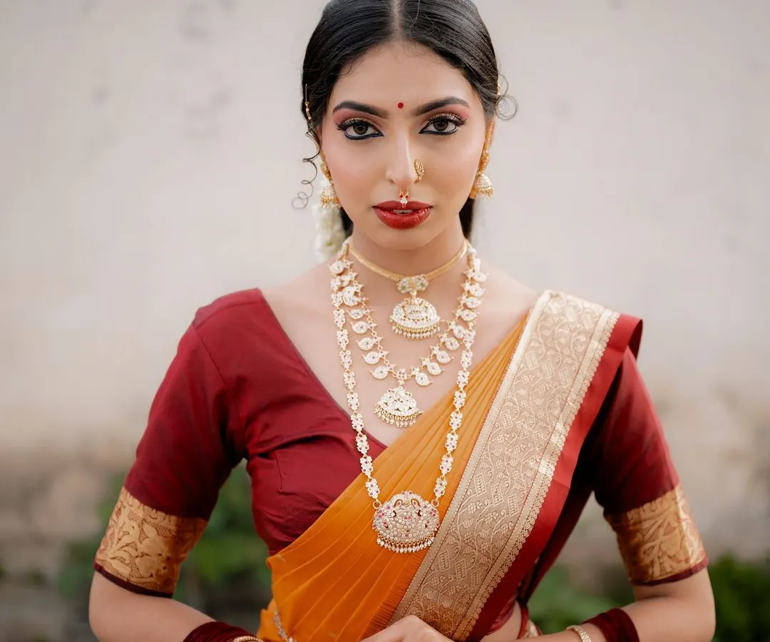 A timeless South Indian bridal portrait. I focused on her elegant posture and the rich colors of her Kanjeevaram saree, using natural light to highlight the intricate details of her temple jewellery.