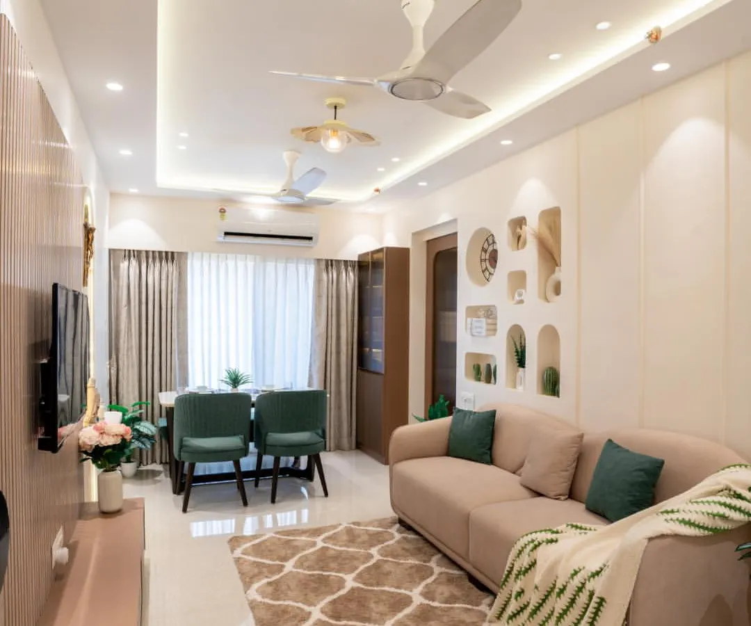 A look at a complete living and dining area we designed. We used a neutral color palette with pops of green, elegant cove lighting on the ceiling, and a mix of textures to create a space that feels both expansive and cozy.