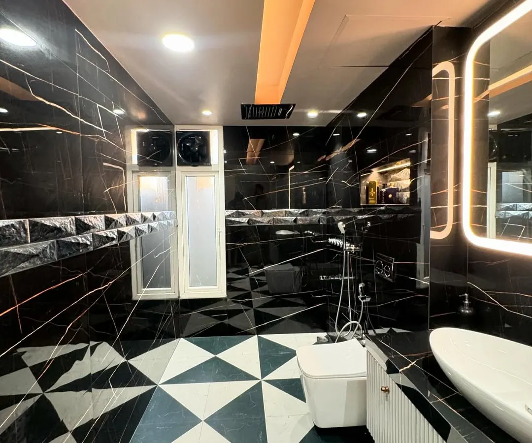 A glimpse into a luxury bathroom I designed, featuring black marble with gold veining and geometric floor tiles. I focus on high-end materials and flawless execution to create spaces like this, handling all the plumbing, tiling, and electrical work myself.