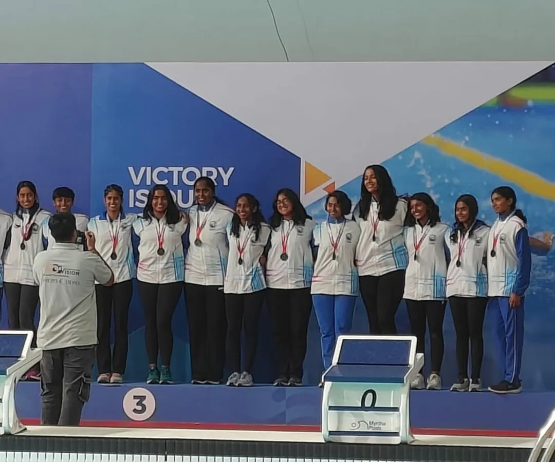 A proud moment for our water polo women's team on the podium, displaying their bronze medals after a historic win at the 78th Senior Nationals Aquatic Championship. This victory for Karnataka came after a ten-year wait.