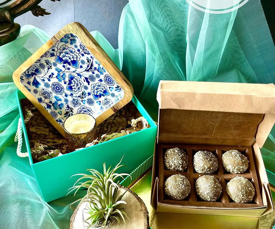 I love how this hamper turned out. The star is the beautiful square platter with its intricate blue and white enamel work, paired with a box of delicious upcycled sweets. We added a little botanical friend, an air plant, nestled in a rustic wood holder to bring a touch of green life to your home.