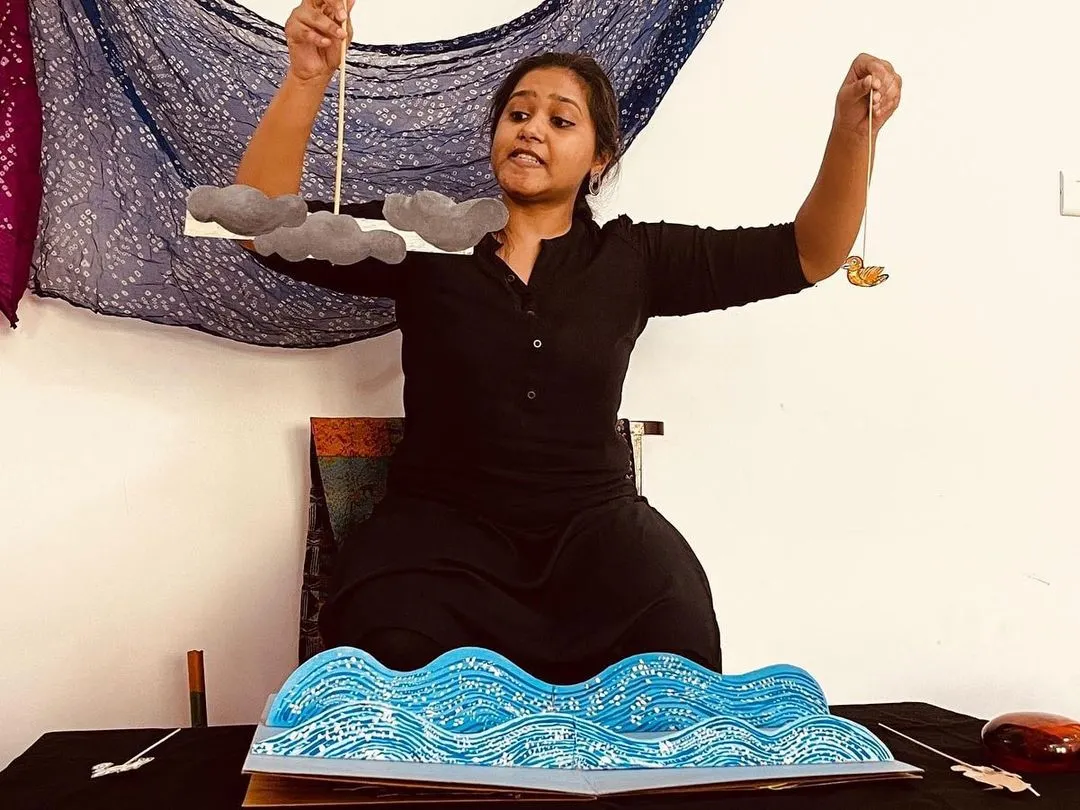We use all kinds of creative tools to tell our stories. Here, I am using simple paper cutouts and a pop-up book to create a world of waves and clouds during an interactive storytelling session.