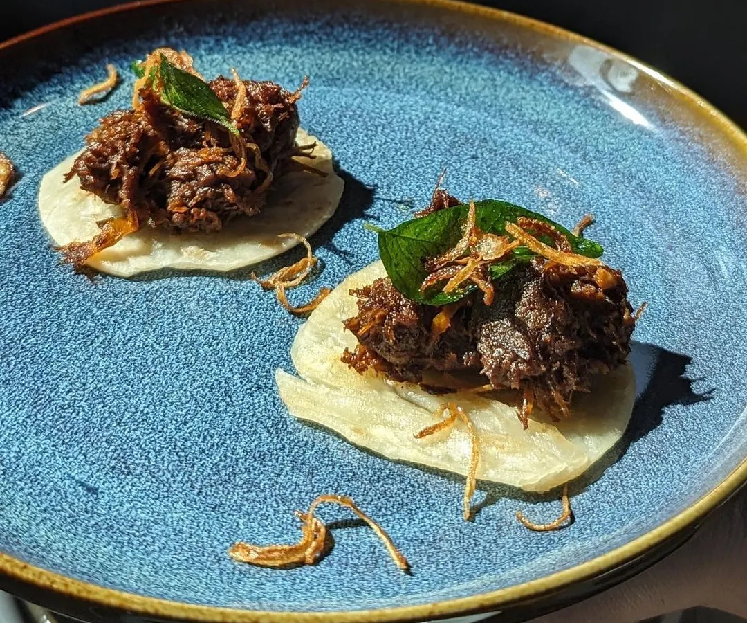 My Beef Ullarthu is a true labour of love and a Syrian Christian classic. I slow roast succulent beef chunks with my own hand-ground aromatic masala, coconut chips, and curry leaves until it's perfectly tender. Here, I have served it on mini parottas, making it the perfect bite-sized starter for any party.