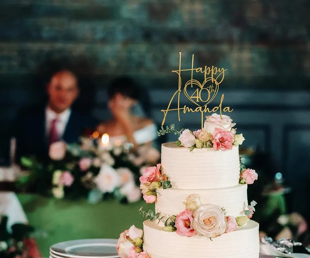 For Amanda's 40th birthday, I designed this elegant three-tiered cake with delicate pink and white roses. The custom gold topper adds a personal touch, making it a perfect centerpiece for a milestone celebration.