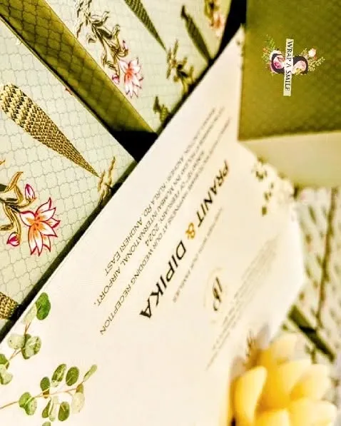 A wedding invitation is the first chapter of your story. This mint green invitation box, featuring a Moroccan design and lotus stem motifs, holds two jars of nuts and a graceful invite, setting a tone of sophisticated elegance for the celebration.