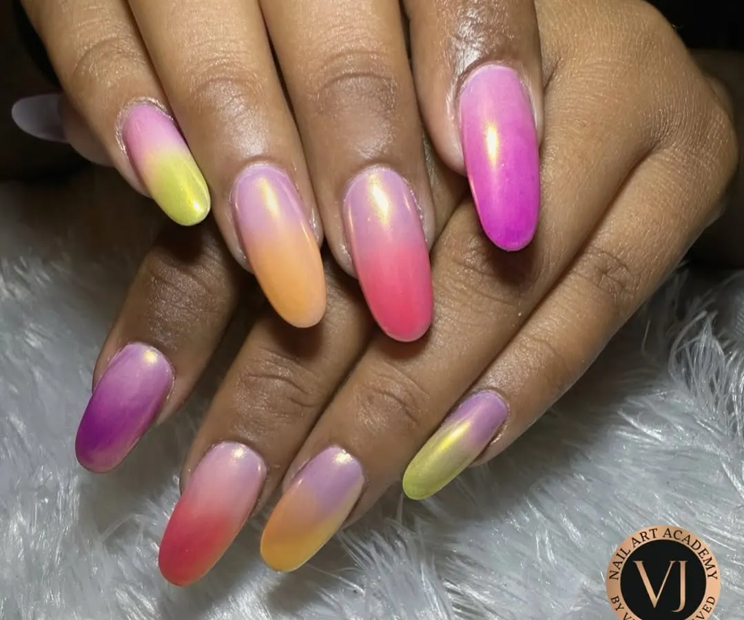 We love playing with color, and these vibrant ombré nails are a testament to that. This set showcases a flawless gradient of sunset hues, blending from fuchsia and orange to sunny yellow, finished with a pearlescent sheen for a magical, tropical vibe.
