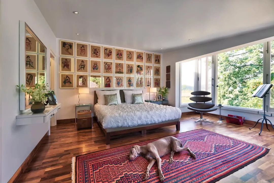 In the Aishbagh holiday home, a bedroom becomes a personal sanctuary with a view of Damdama Lake. We believe in spaces that connect with their surroundings, using natural light, art like these Kalighat paintings, and rich textiles like the Kurdish kilim to create a sense of place and peaceful retreat.
