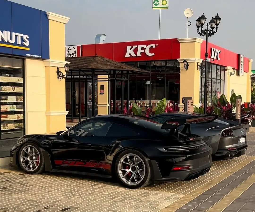 We are a popular meet-up spot for car enthusiasts. Here, a sleek Porsche GT3 and a Toyota Supra are seen parked outside our KFC outlet, showcasing the high-energy vibe you can expect.