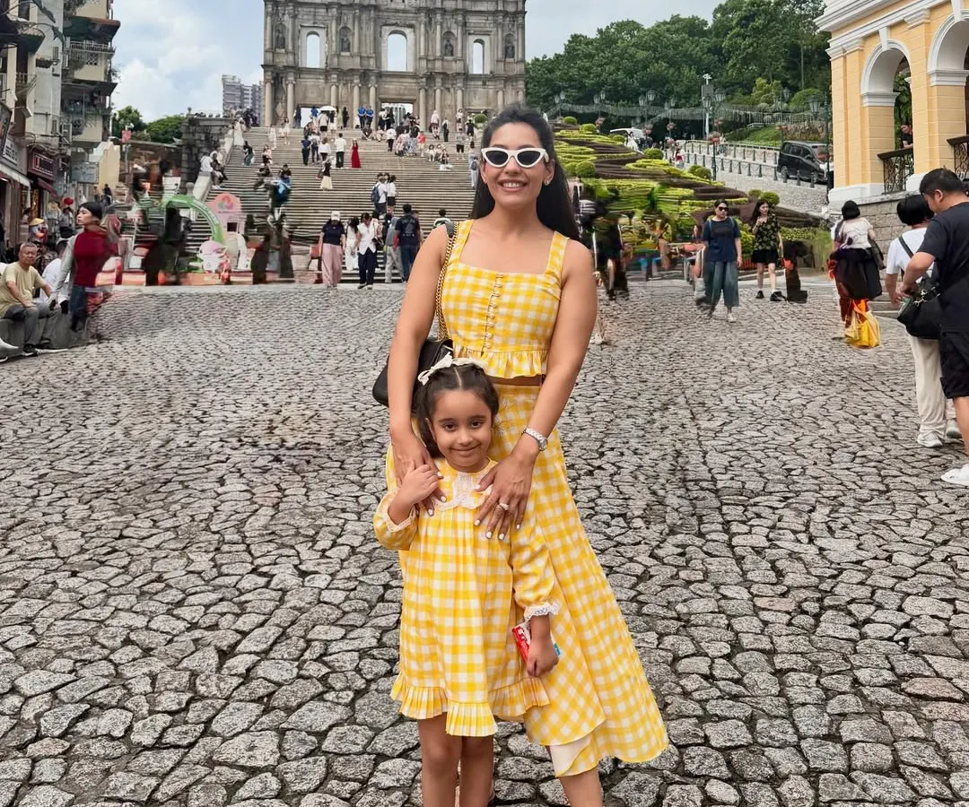 Creating memories on vacation is even more special in matching outfits. I designed this bright yellow gingham check co-ord set, featuring a crop top and asymmetrical skirt for myself, and a matching dress for my little one. It’s the perfect custom vacation look for a mother-daughter duo.