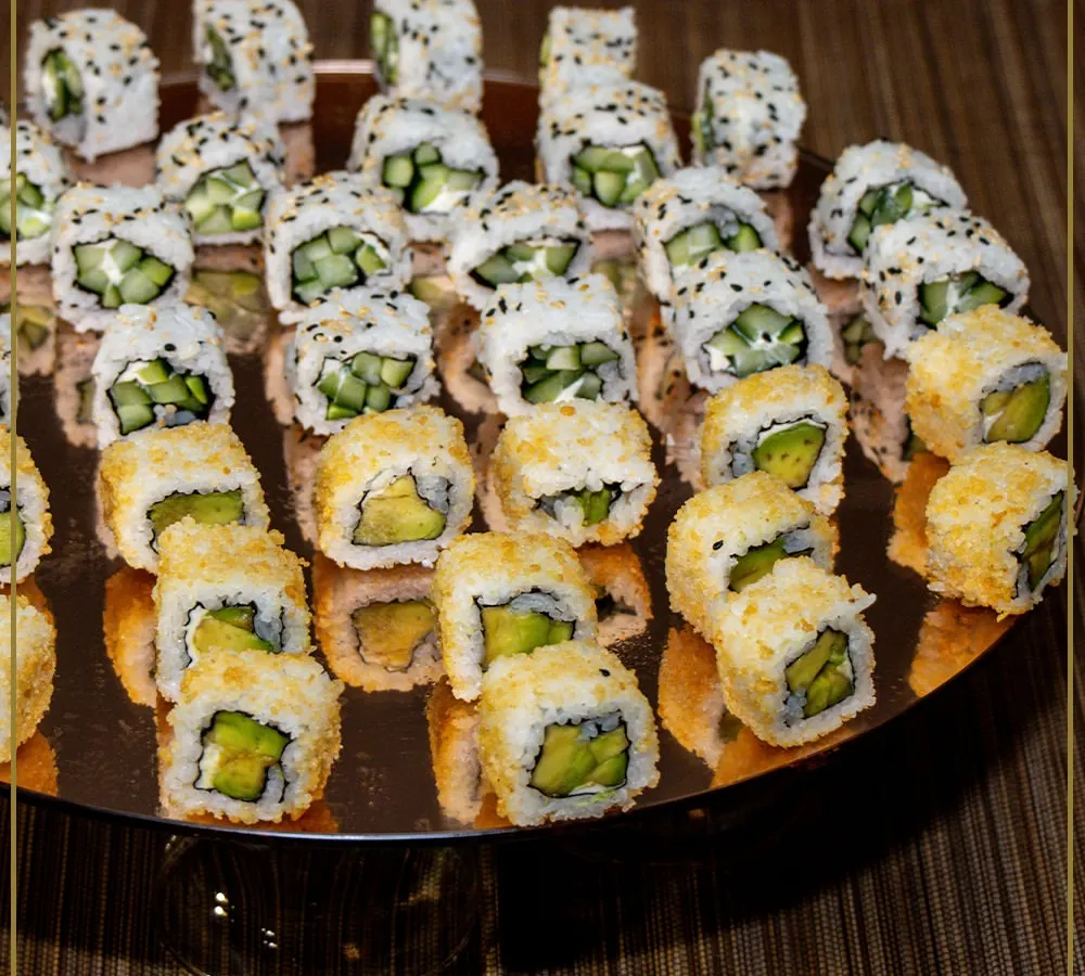 We believe in culinary artistry. This platter of freshly prepared avocado and cucumber sushi rolls showcases our commitment to beautiful presentation and high-quality ingredients for our global cuisine offerings.