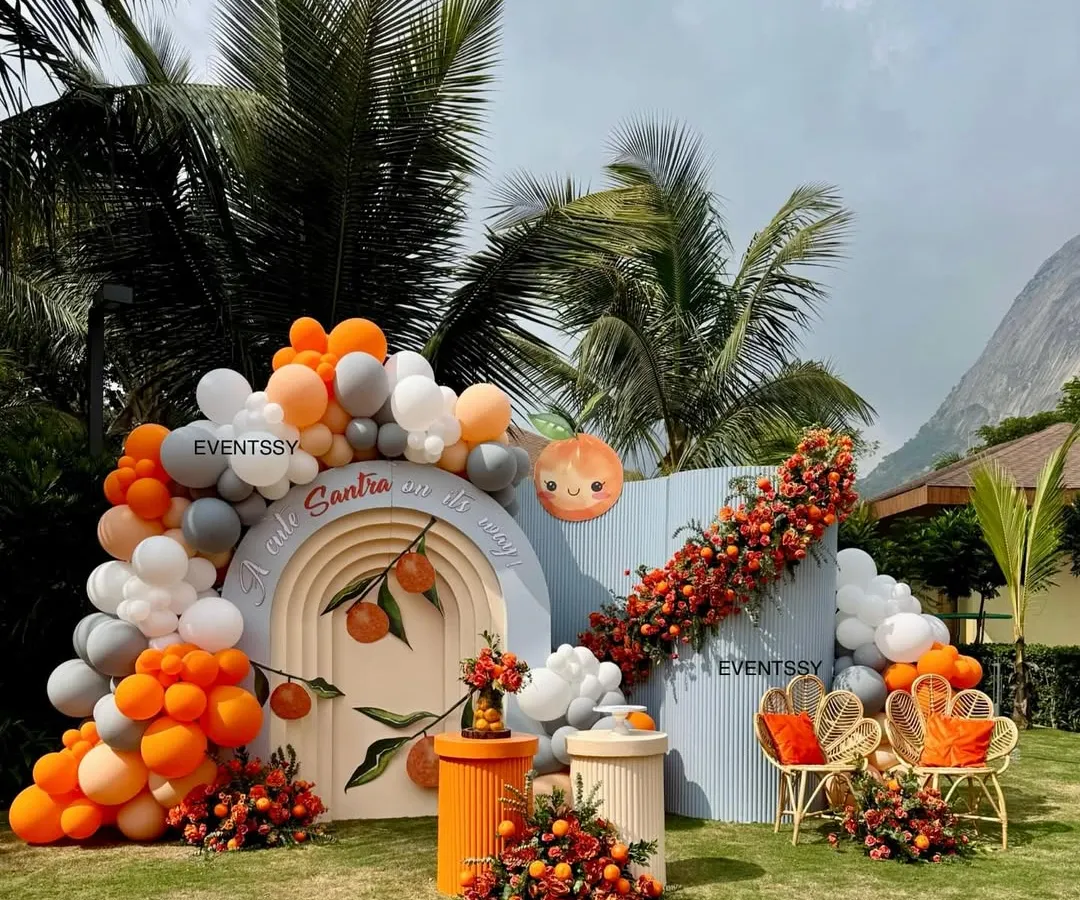 A look at my "Tangerine & Twinkles" baby shower theme, where we used an arch backdrop, custom seating, and vibrant balloon garlands. I love incorporating unique elements like real santras into the floral arrangements for a fresh, memorable touch.