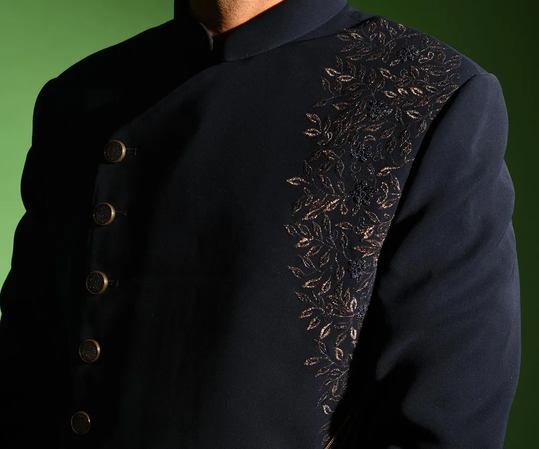 A close up of my asymmetric Indo western jacket, showcasing the detailed leaf pattern embroidery in contrasting thread. This piece blends sharp, modern tailoring with traditional craftsmanship for a standout reception or sangeet outfit.