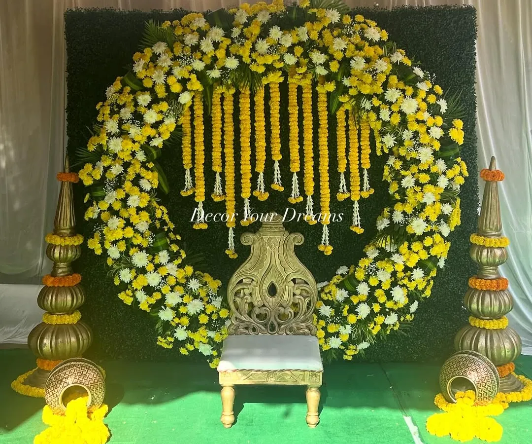 A perfect example of our vibrant Haldi ceremony decor. We created a full circular arch with yellow marigolds and white chrysanthemums, complete with a traditional seat and decorative pots, making for a stunning photo opportunity.