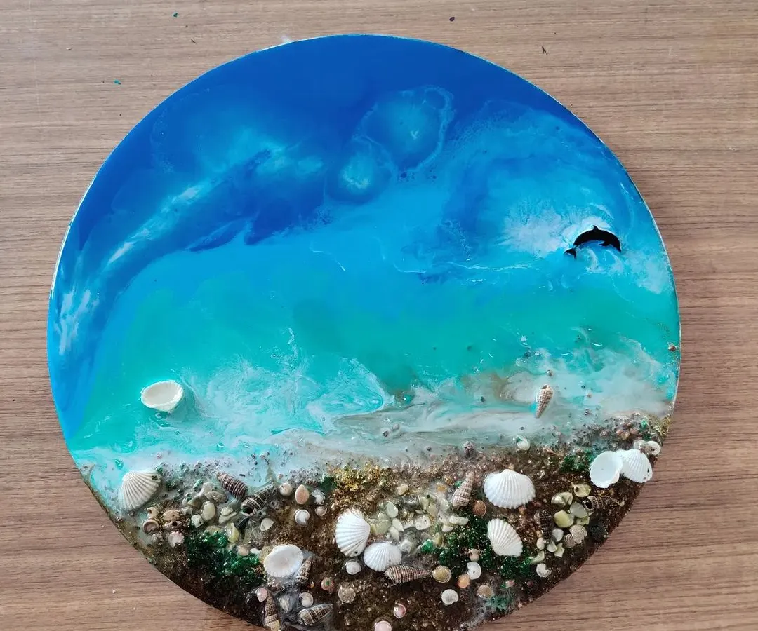 This is the stunning result of our beginner-friendly Resin Ocean Art workshop. Participants learn to mix pigments and pour resin to create these beautiful, glossy ocean scenes complete with real shells.