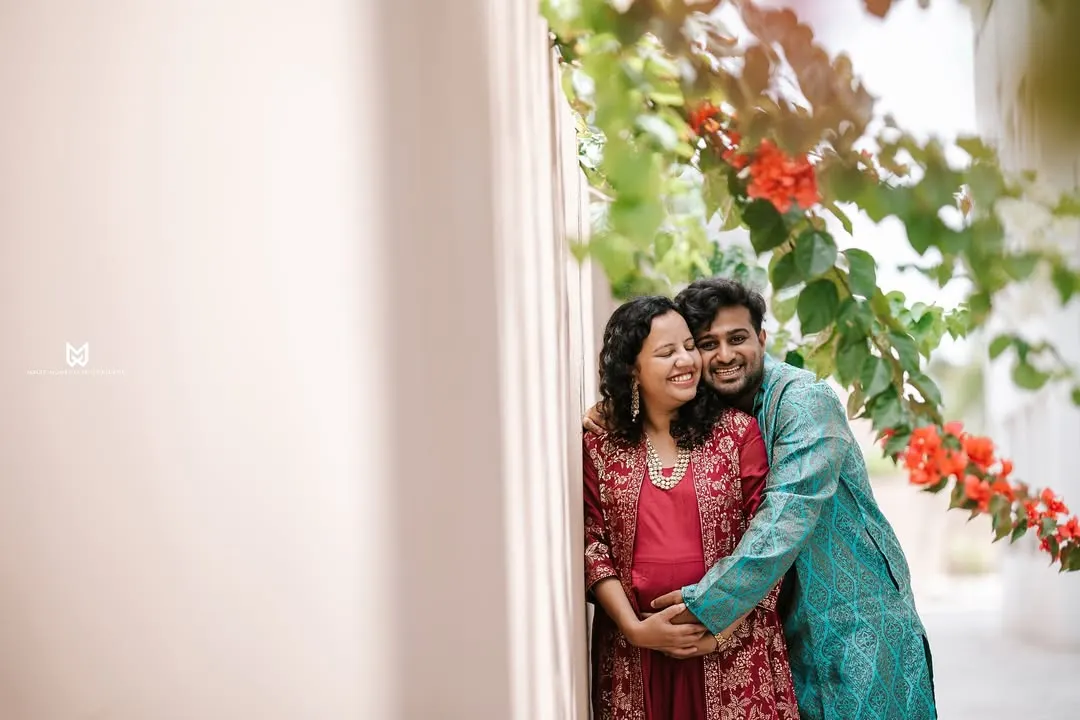 A quiet moment of connection for this expecting couple. We used the soft morning light and vibrant bougainvillea to frame their embrace during this outdoor maternity photoshoot.