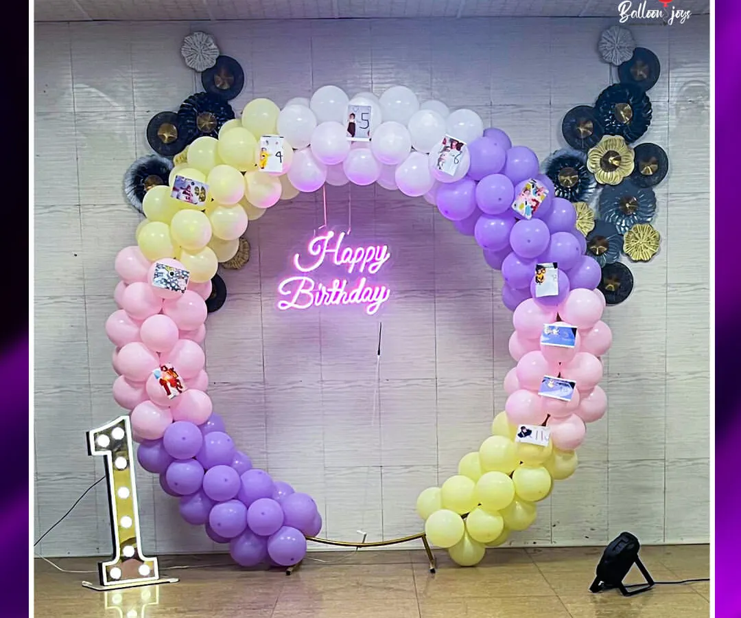 For a baby's first birthday, we created this vibrant, circular balloon arch with a custom "Happy Birthday" neon sign. To make it extra personal, we attached cherished family photos, creating a beautiful memory lane for the parents and guests.