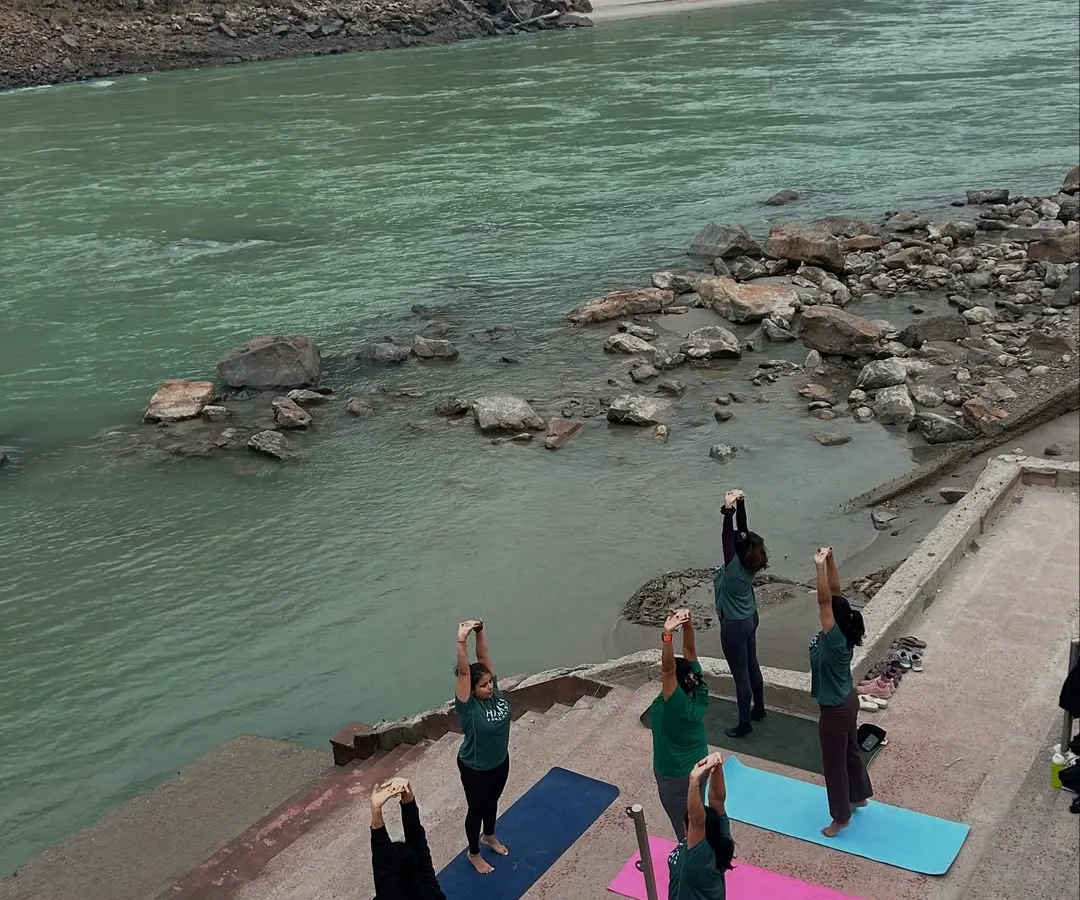 From a bird's eye view, our tribe salutes the sun on the banks of the holy Ganga. Practicing yoga in Rishikesh, surrounded by the tranquil sounds of the river and fresh mountain air, is an experience that rejuvenates the body and soul.