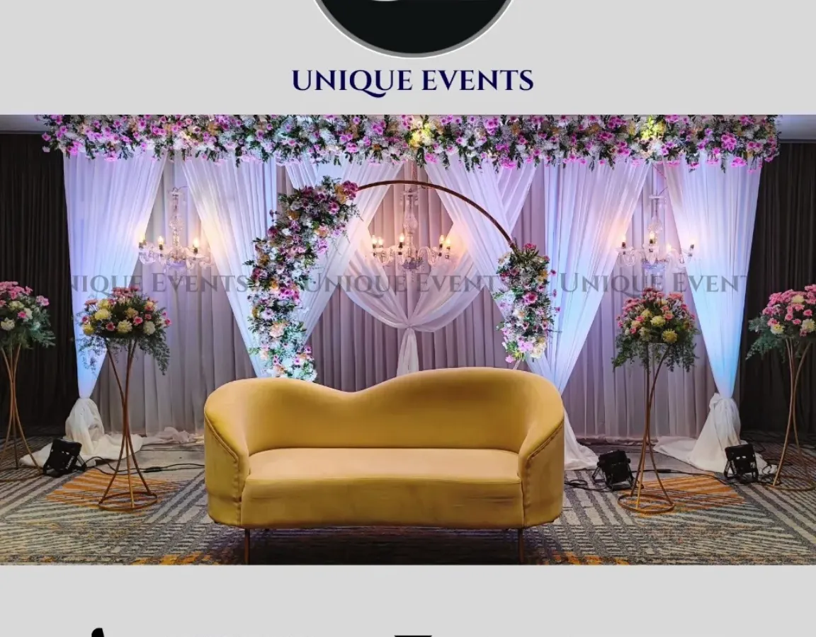 This is an example of a modern and elegant stage design perfect for a reception or engagement party. I combined a clean, circular floral arch with soft white curtains and classic chandeliers to create a sophisticated focal point for the couple.