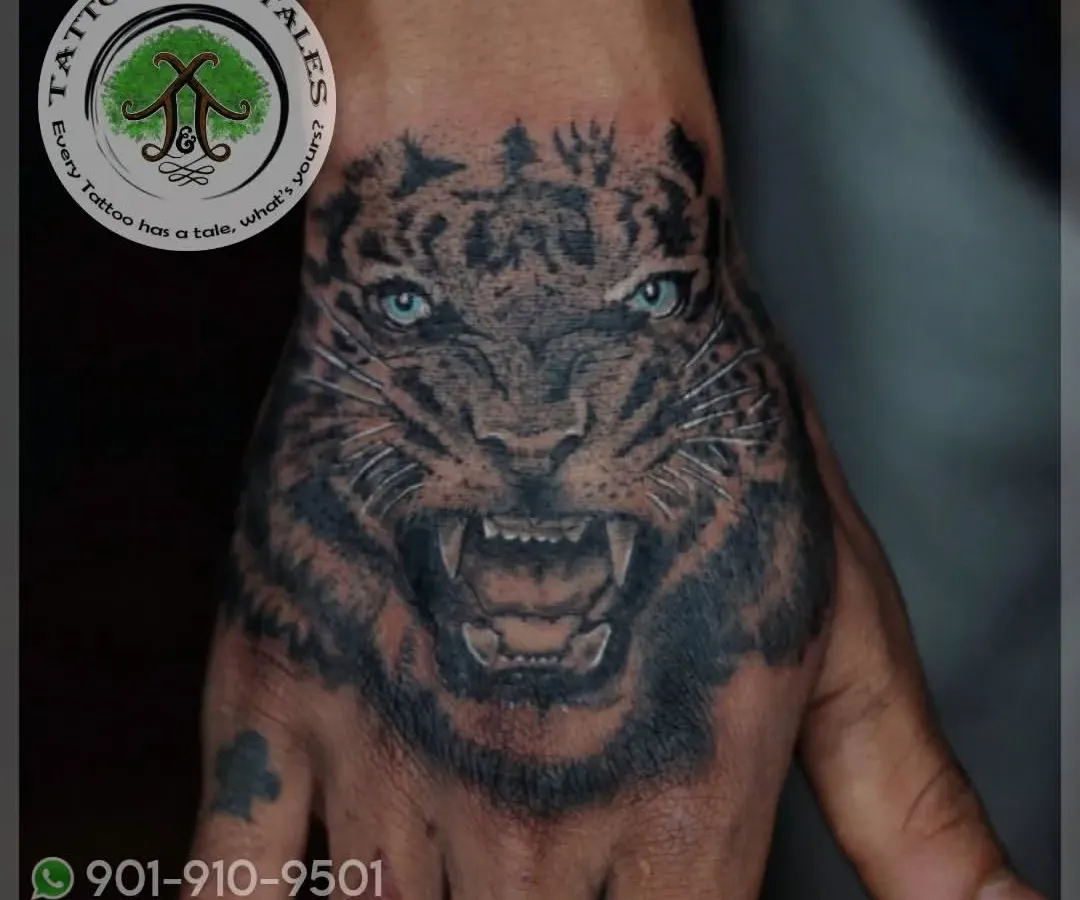 A realistic tiger tattoo, placed right on the hand. This kind of detailed black and grey work in a high-motion area requires precision and expertise to ensure it heals and lasts beautifully.