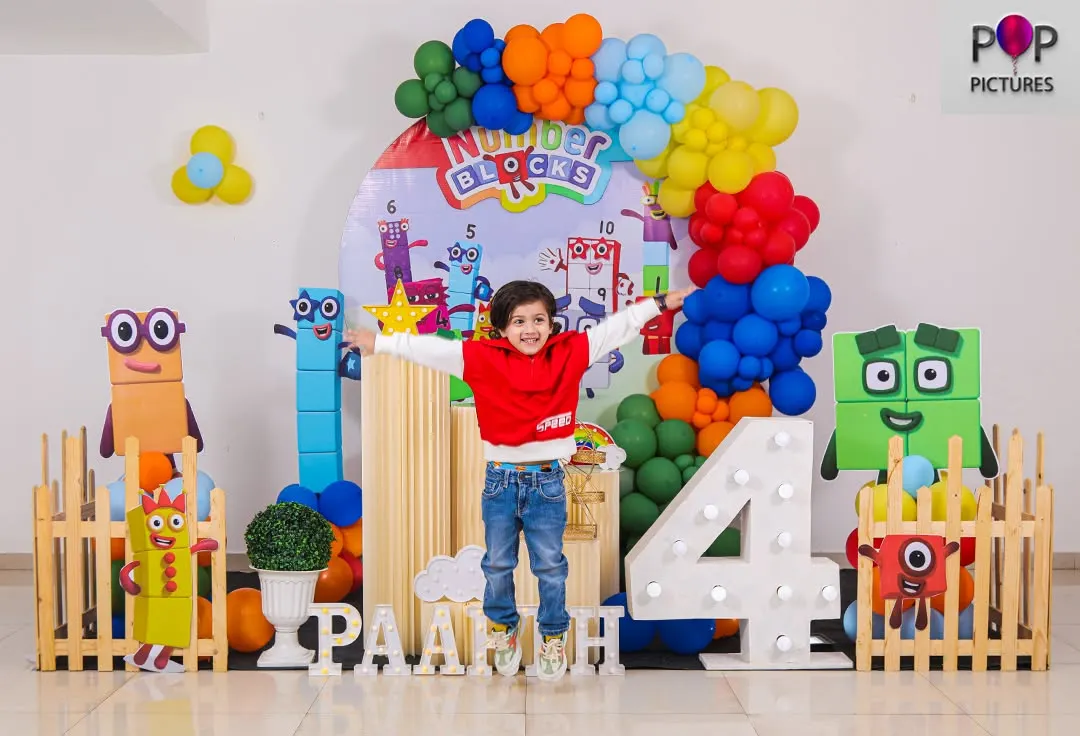 Pure joy in mid-air! We love capturing the energy of a party, like this little one jumping for joy at his action-packed Numberblocks themed 4th birthday. This setup included character cutouts, a colorful balloon arch, and a large light-up number four.
