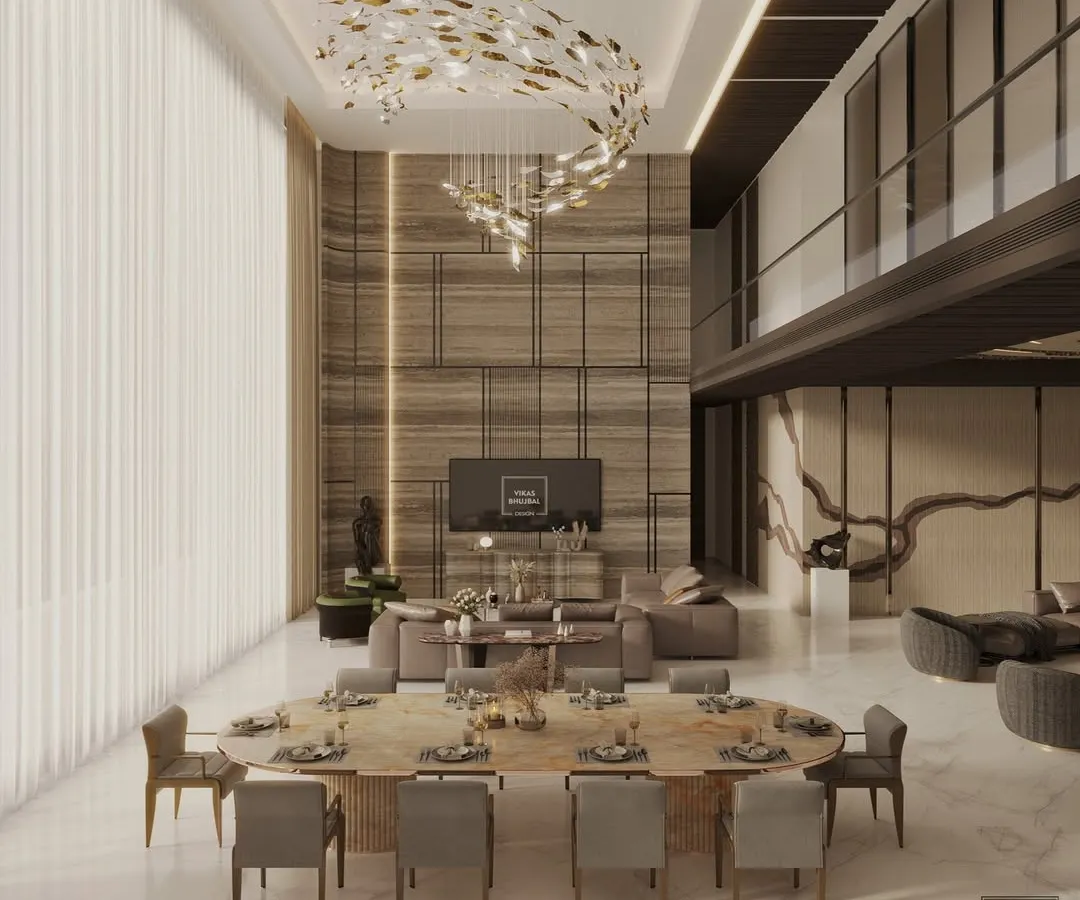 A glimpse into a double-height living and dining area we designed for a luxury penthouse in Mumbai. The space is defined by a dramatic sculptural chandelier, bespoke furnishings, and a mezzanine level, all curated to create an atmosphere of refined elegance.