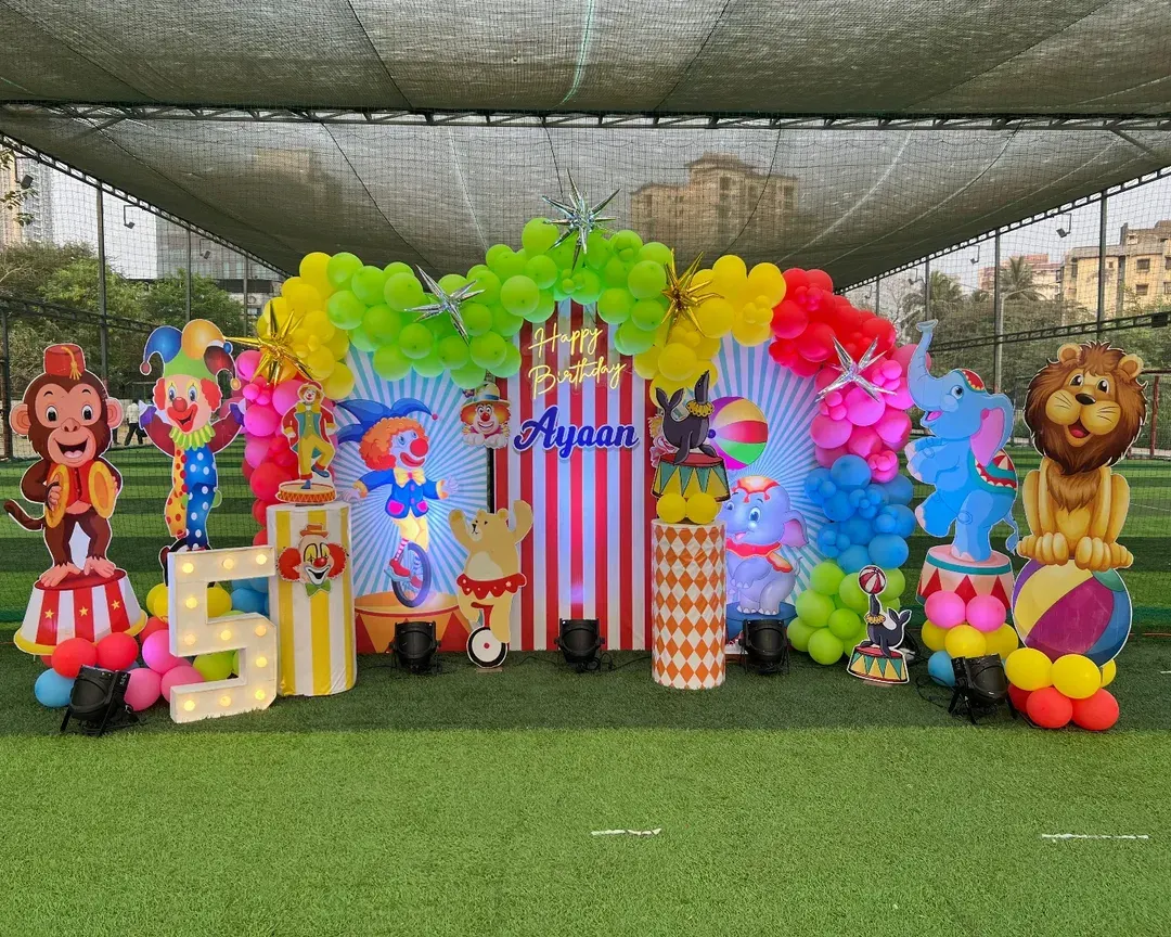 We created a full-scale carnival theme for this outdoor 5th birthday party. The setup includes a vibrant balloon arch, life-sized cutouts of circus animals and clowns, and custom-striped pedestals for a truly immersive experience.