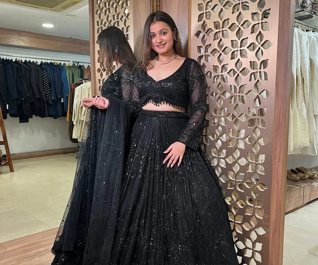 Make a bold statement at your next cocktail or reception party with this stunning all-black sequined lehenga. This full-length view shows the incredible sparkle and flow of the skirt, a perfect pre-loved designer find.