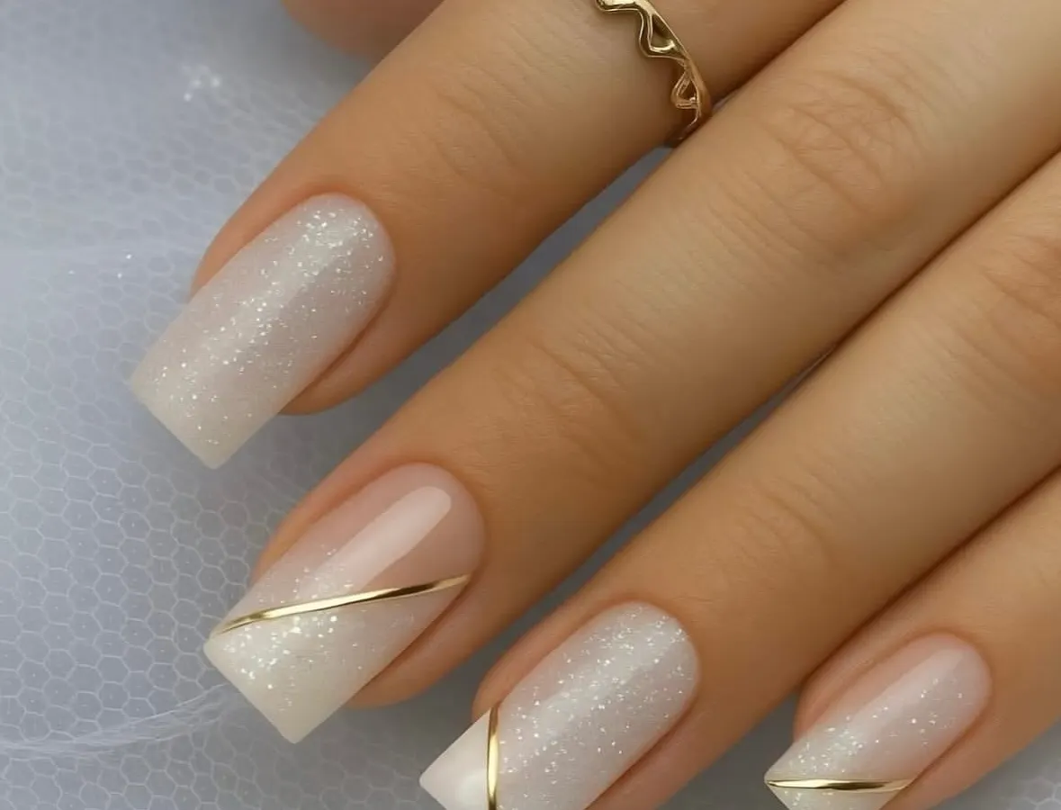 This is the kind of perfection we aim for. A clean, elegant bridal nail set with a shimmering base and a delicate gold line accent. Mastering these classic looks is a core part of my nail technician training.
