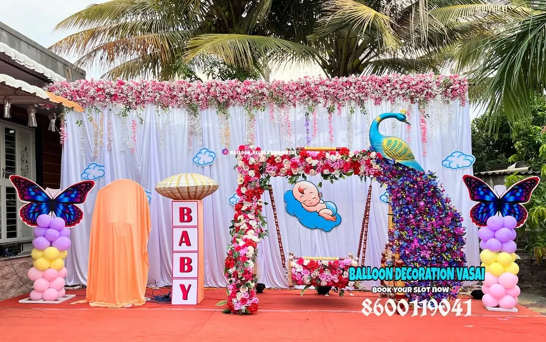For a grand and traditional naming ceremony, I created this stunning outdoor setup featuring a floral peacock and a beautifully decorated baby jhula (cradle). The design combines vibrant colors with classic cultural elements for a truly royal feel.