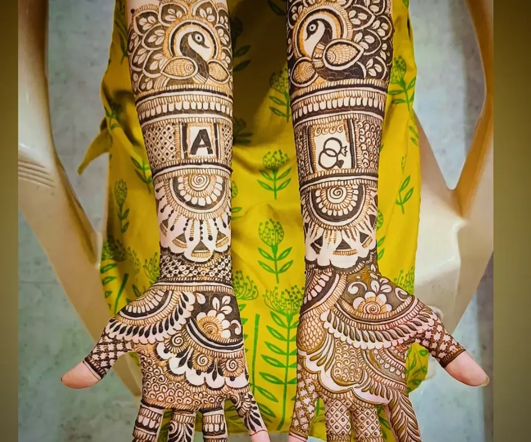 I specialize in personalizing your bridal mehandi. Here, I incorporated the groom's initial 'A' and a pair of elegant peacocks, which symbolize beauty and grace in Indian culture.