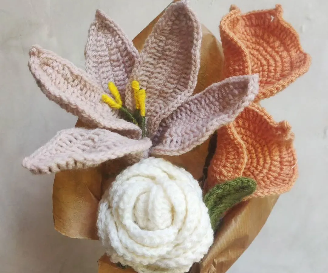 A bouquet that lasts forever. This arrangement features a mix of handmade crochet flowers, including delicate lilies and a classic white rose. It's a perfect, timeless gift for any occasion, bringing a touch of handmade beauty into your home without ever wilting.