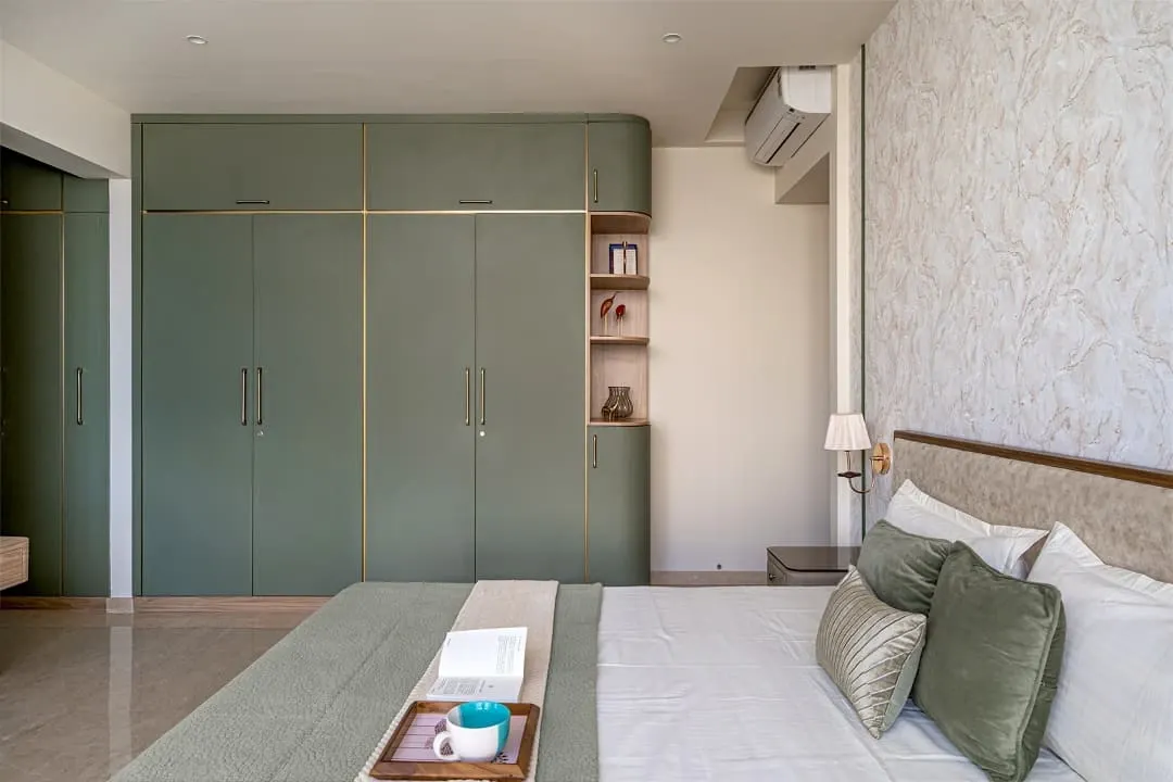 For this master bedroom in Thane, we aimed for simple sophistication. I built the custom wardrobe with curved edges and subtle gold accents to create a soft, luxurious feel. The entire room is designed to be a calm and warm space.
