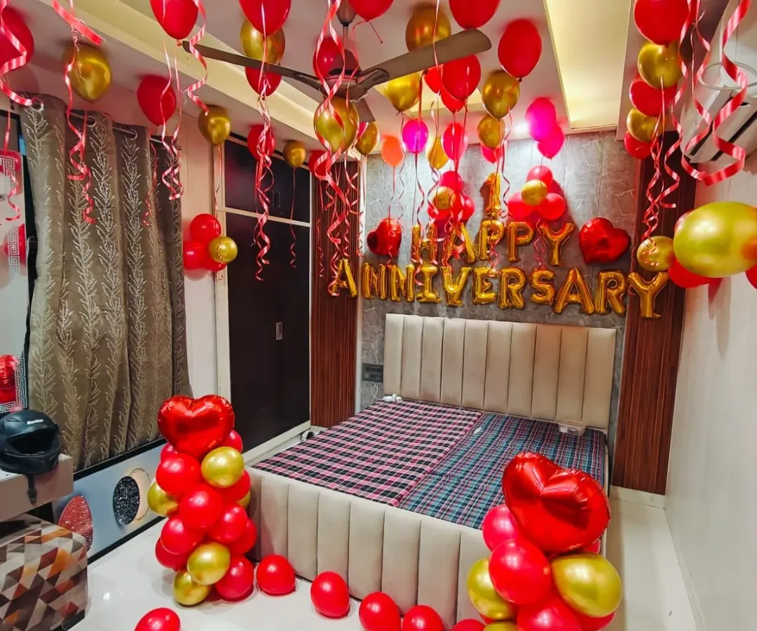 For a classic and romantic surprise, I can transform your bedroom with a full decoration package. This setup includes red and gold latex balloons, "Happy Anniversary" foil lettering, heart-shaped balloon bouquets, and ribbons hanging from the ceiling.