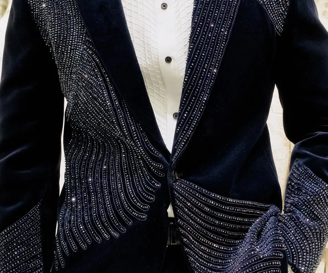 It's all about the details. This close-up shows the precise, handcrafted beadwork on one of our signature velvet reception blazers, designed to catch the light and everyone's attention.