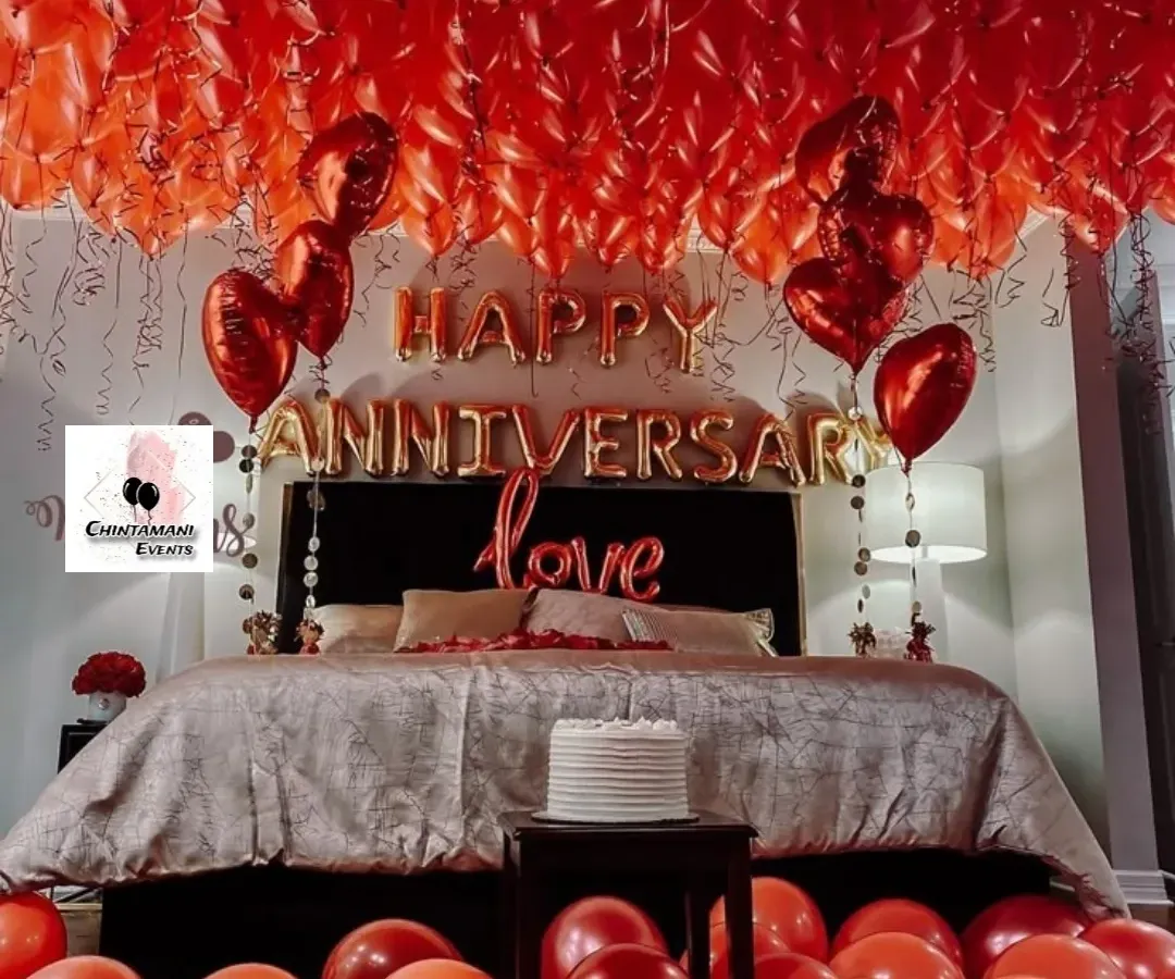 This is my classic romantic anniversary room decoration, a popular choice for surprising a partner. The entire ceiling is covered with red balloons, complemented by 'Happy Anniversary' foil letters and heart-shaped balloons, turning a simple bedroom into a luxurious and passionate retreat.