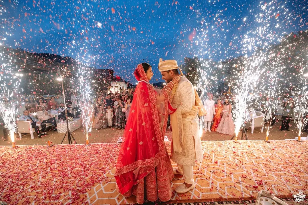 The magical moment of the varmala exchange, illuminated by a shower of fireworks. This is the kind of grand, unforgettable shot that defines a wedding celebration.
