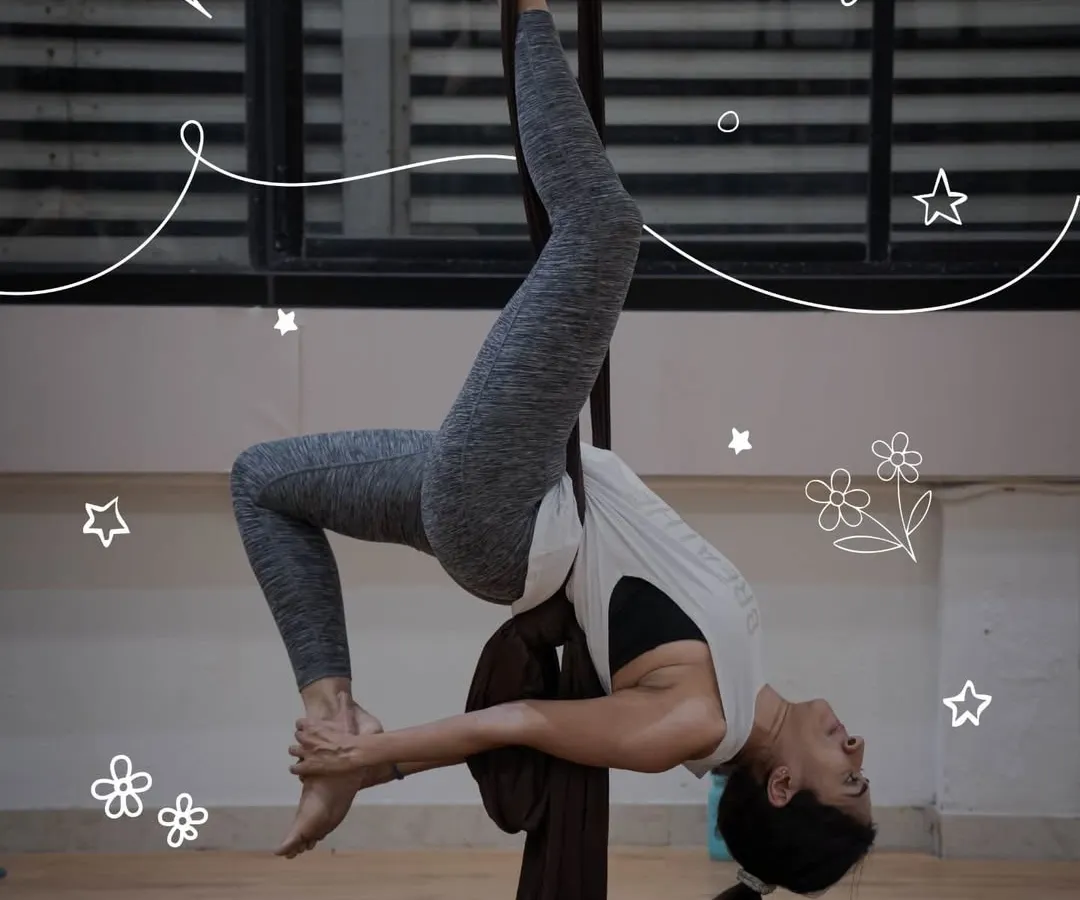 Discover a unique blend of strength and artistry in our aerial silk workshops. This participant showcases the beautiful shapes you can create while suspended, building confidence with every move.