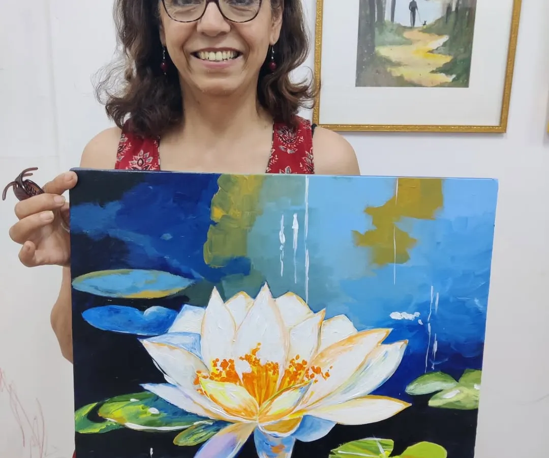 It's never too late to create something beautiful. This student is all smiles with her stunning acrylic painting of a water lily, created during one of our relaxing art workshops for adults.