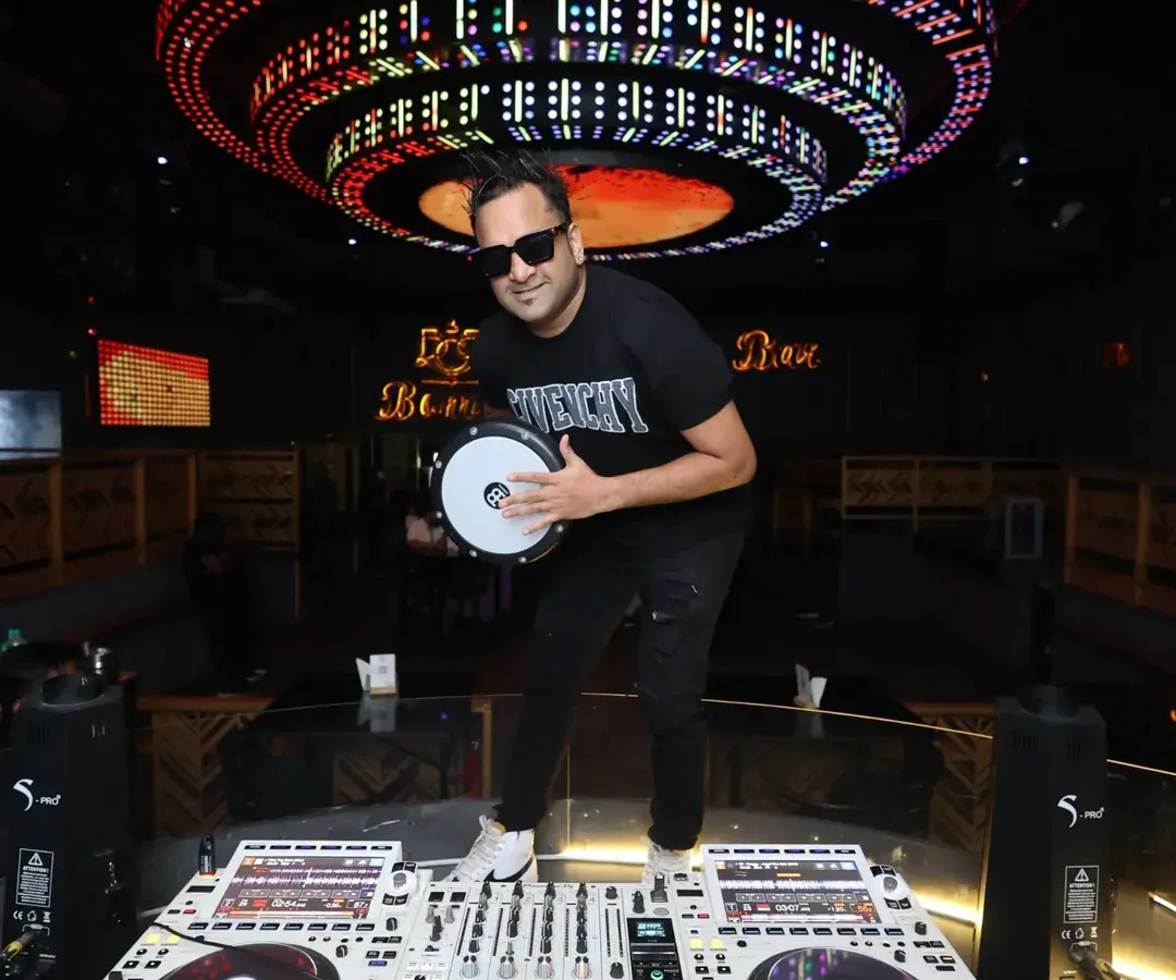 Here I am in my element at Bombay Cocktail Bar, ready to drop the beat. With my Pioneer DJ setup and my Darbuka drum, I'm prepared to deliver a unique set that blends electronic music with live tribal rhythms.