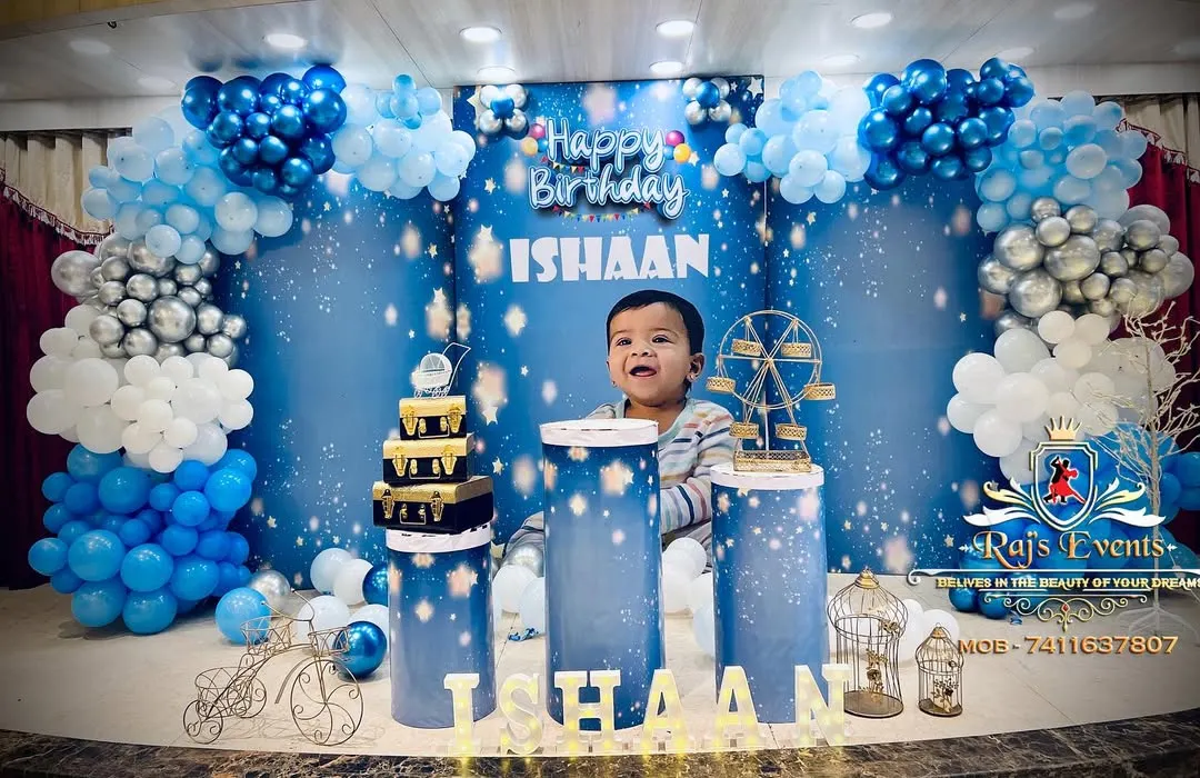 This is a glimpse into our 'Twinkle Twinkle Little Star' theme, where we create a dreamy celestial world. The setup features a custom backdrop, themed pedestals for the cake, and a multi-layered balloon arch in shades of blue, silver, and white to bring the night sky indoors.