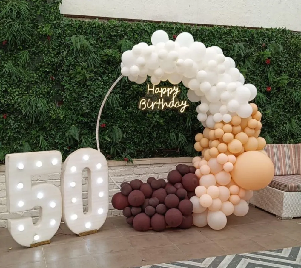 We make milestone birthdays truly special. This elegant 50th birthday setup features large marquee numbers, a modern circular frame, and a sophisticated balloon arch in white, caramel, and chocolate tones, perfect for outdoor or indoor venues.