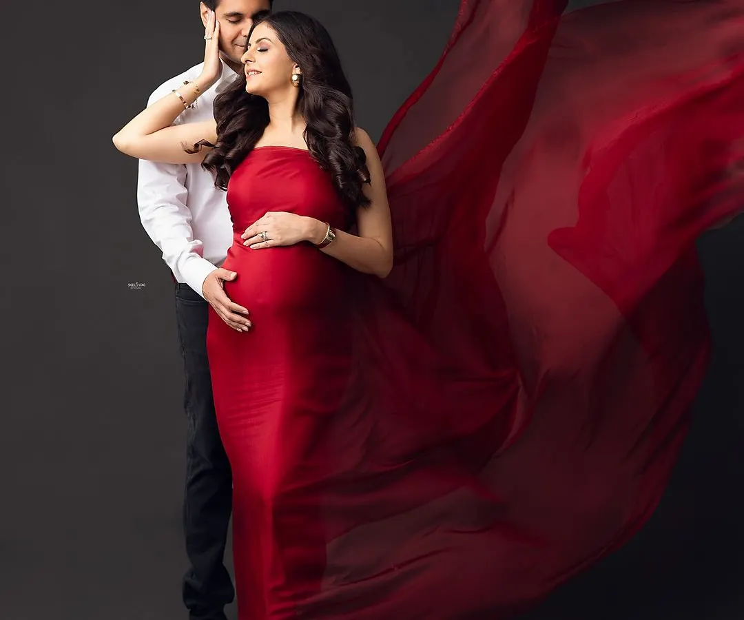 Let's create some magic. For this dramatic maternity portrait, we used a flowing red fabric against a dark backdrop to create a powerful and artistic image that celebrates the beauty of pregnancy. This is for the mamma who wants to feel like a star.