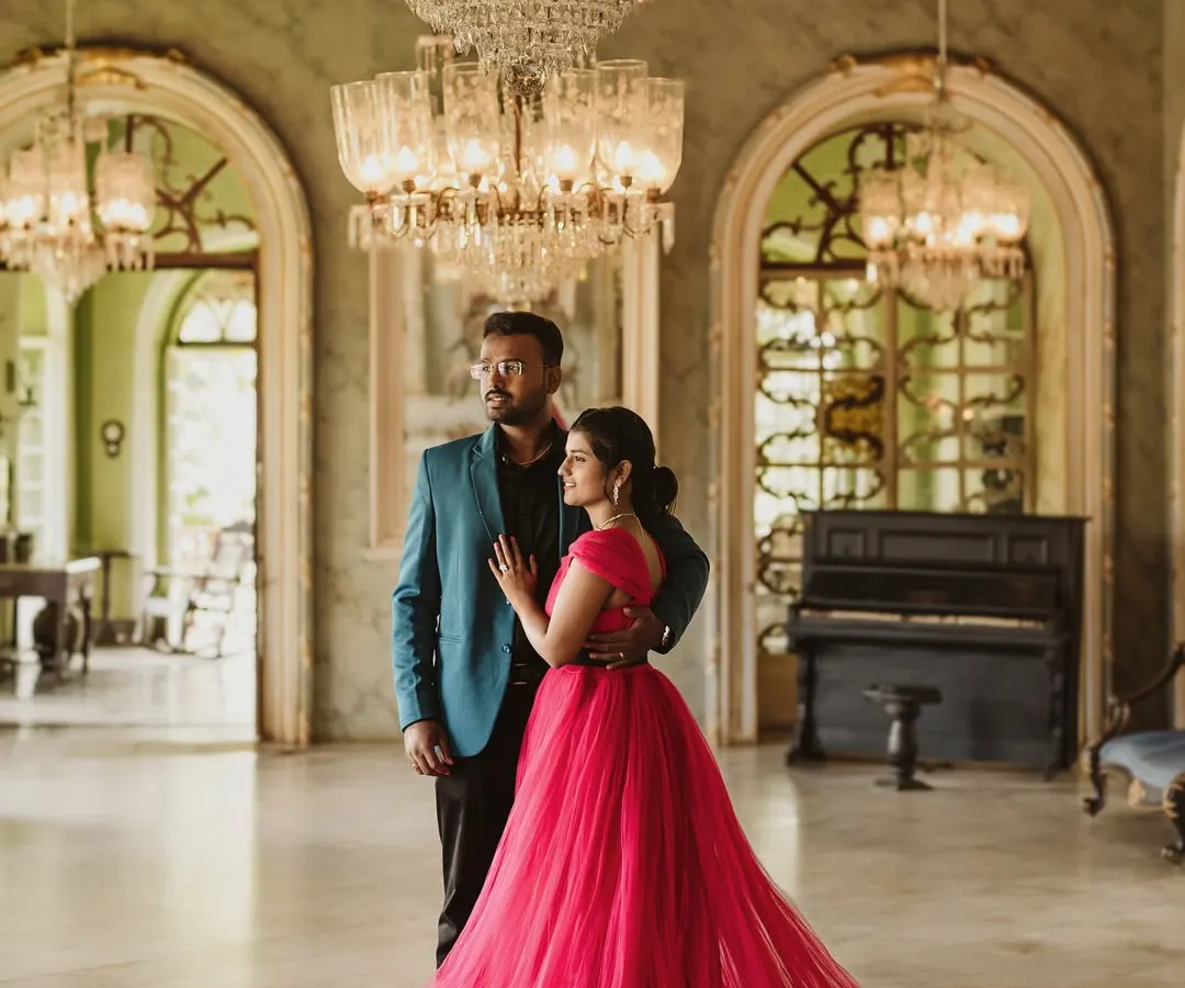 For a touch of royal elegance, this magenta trail gown is a favorite for pre-wedding shoots. Its long, flowing train spreads out beautifully against the grand backdrop of this palace hall, creating a truly cinematic and romantic photograph.