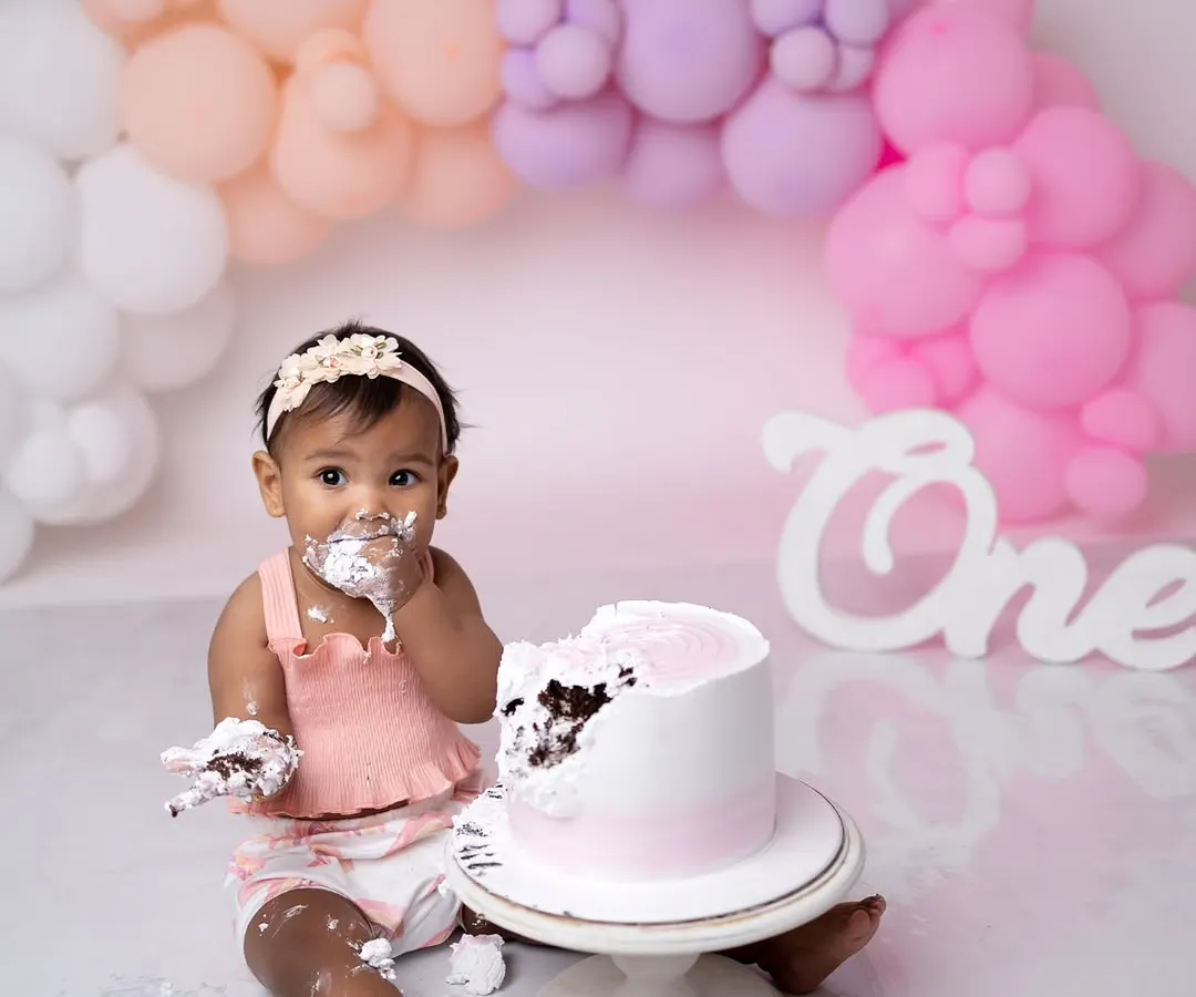 Nothing says "first birthday" like a cake smash! This shot captures the pure, messy joy of a baby digging into their cake for the first time.