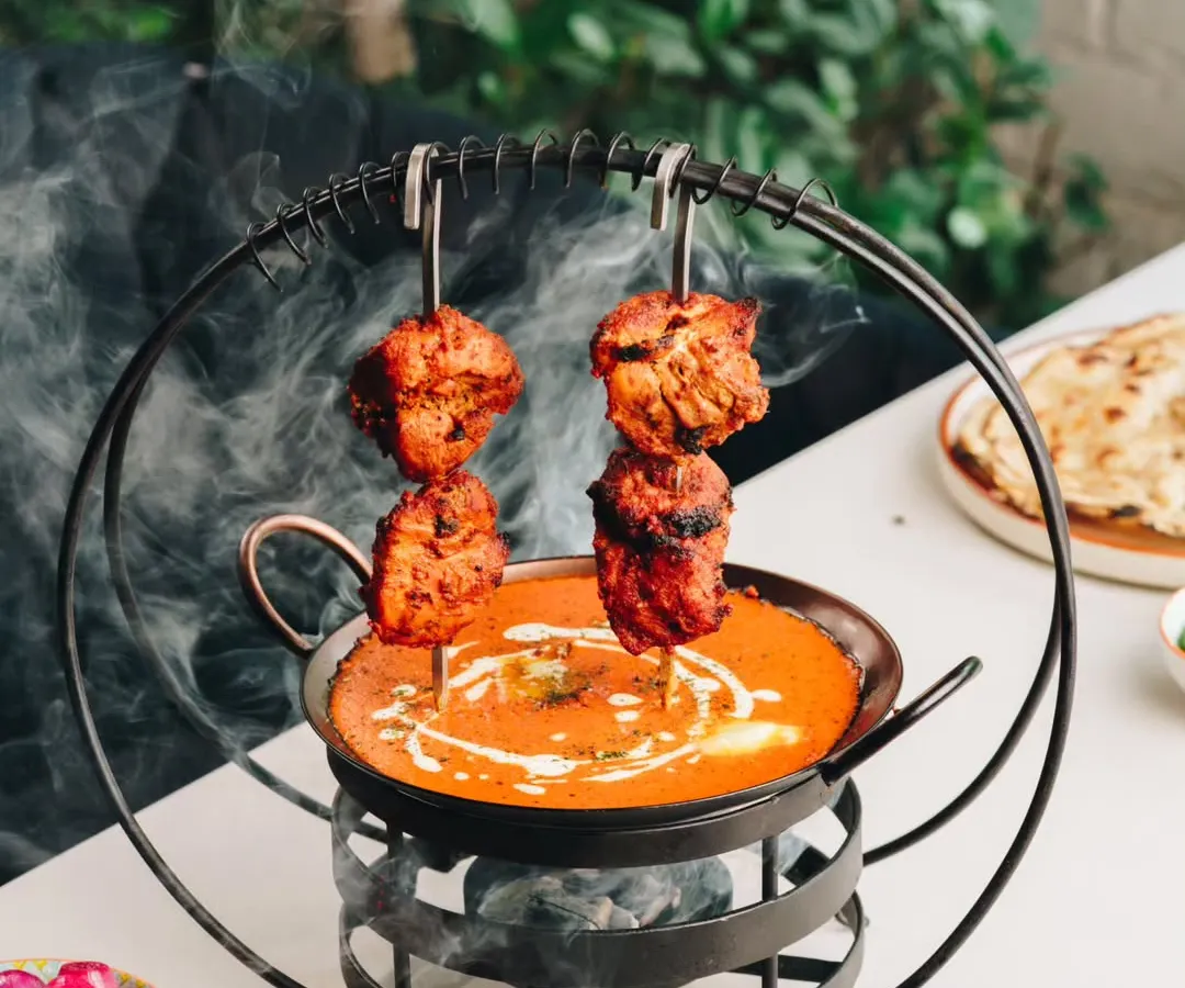 My signature Butter Chicken, presented with a bit of theatre. Succulent tandoori chicken pieces are served over a simmering, velvety tomato-butter gravy, ready to be enjoyed.