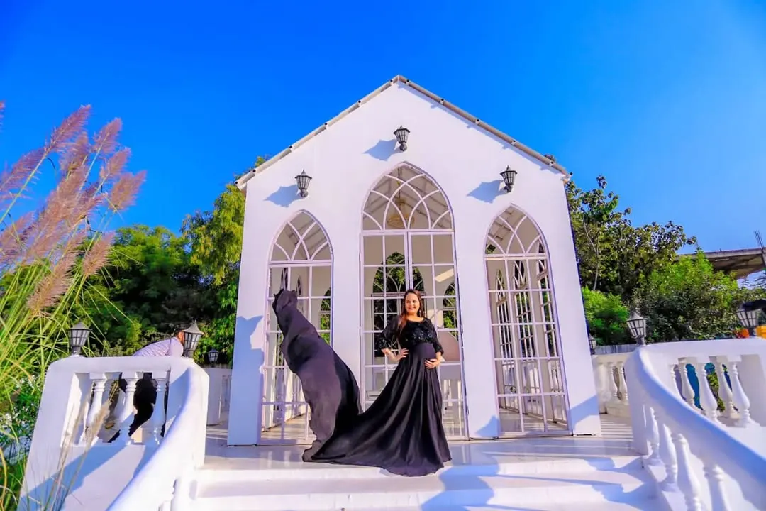 This is for the mothers who want a touch of drama and elegance. We chose an outdoor location with striking architecture to complement this beautiful flowing black gown, creating a powerful and timeless maternity portrait.